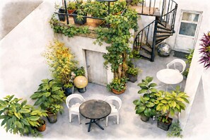 An outdoor patio with a round table and two chairs, surrounded by potted plants and a spiral staircase. - Chambres d'Hotes O Anges (Arles)