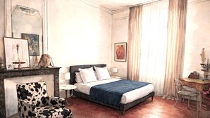A bedroom with a bed, a chair, a desk, a lamp, and a chandelier. - Chambres d'Hotes O Anges (Arles)