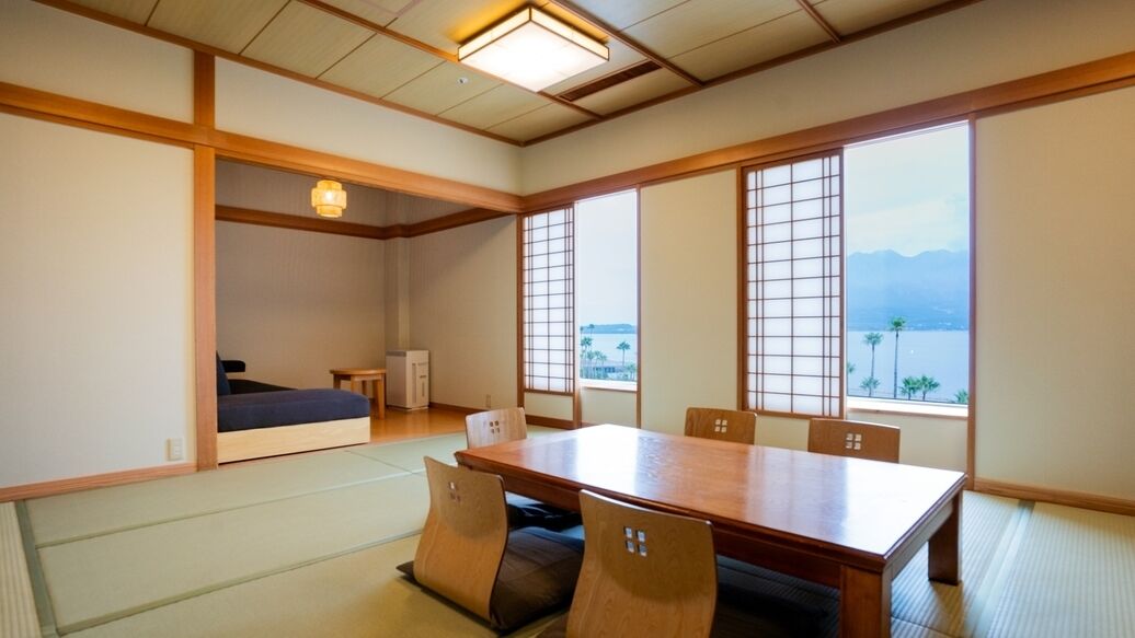 A traditional Japanese room with tatami flooring, a low table, and sliding doors.