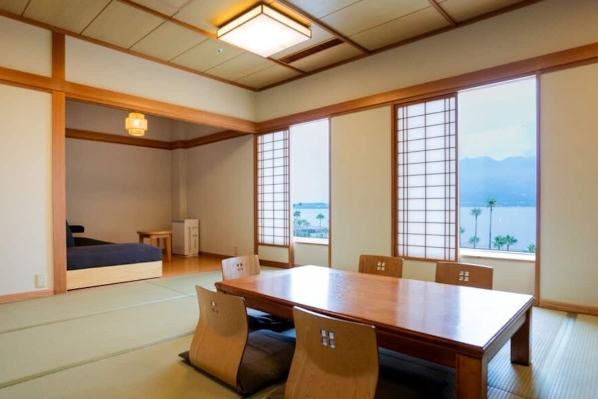 A traditional Japanese room with tatami flooring, a low table, and sliding doors.