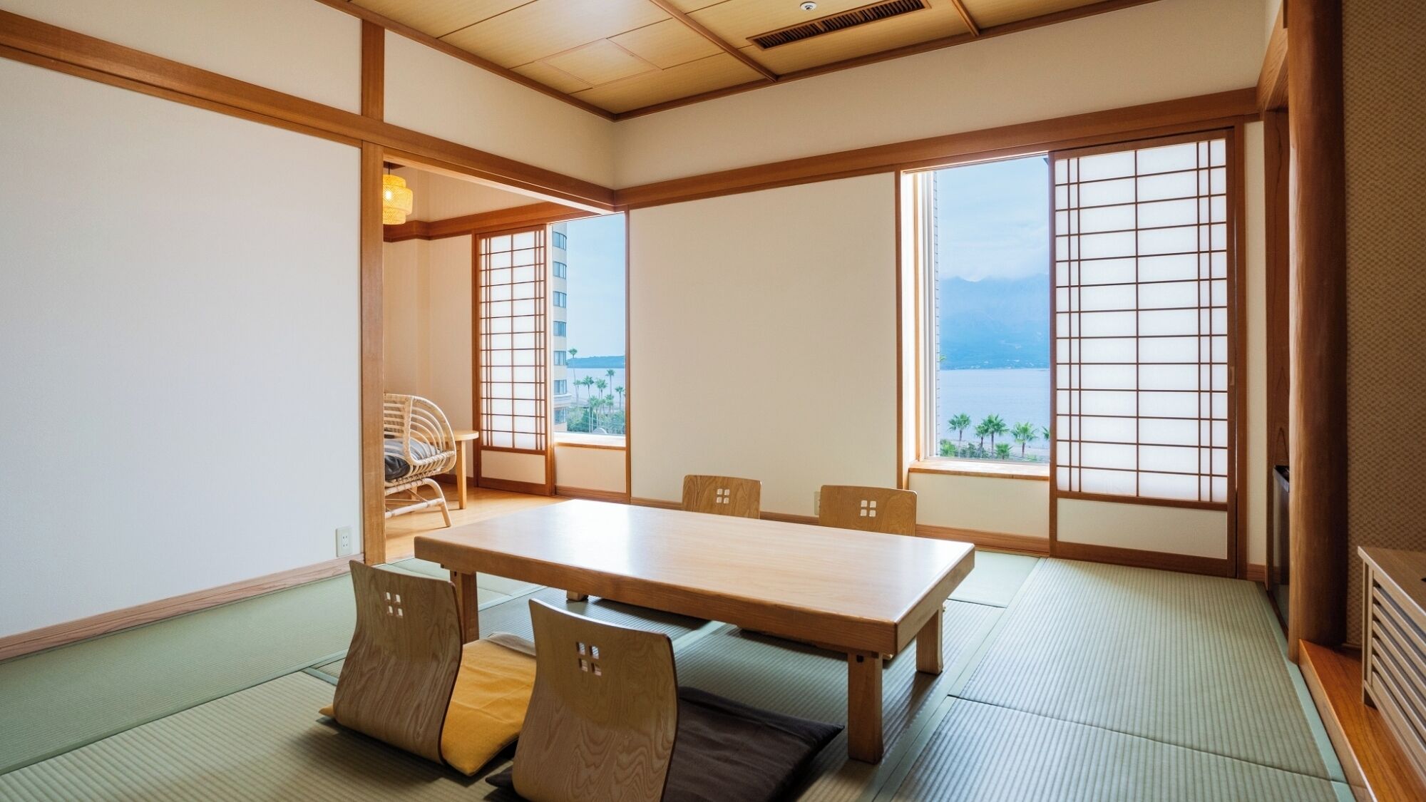 A traditional Japanese room with tatami flooring, a low table, and sliding doors.