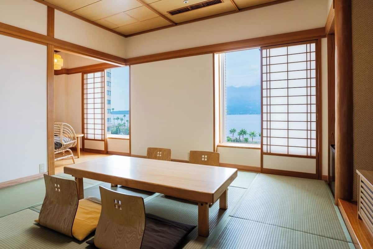 A traditional Japanese room with tatami flooring, a low table, and sliding doors.