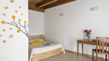 A bedroom with a bed, a desk, and a chair.