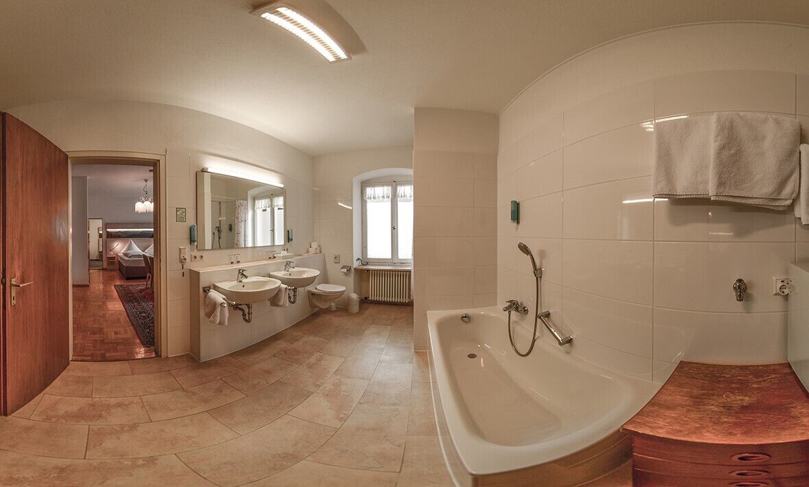 Ein modernes Badezimmer mit einer großzügigen Badewanne, zwei Waschbecken und einer begehbaren Dusche.
