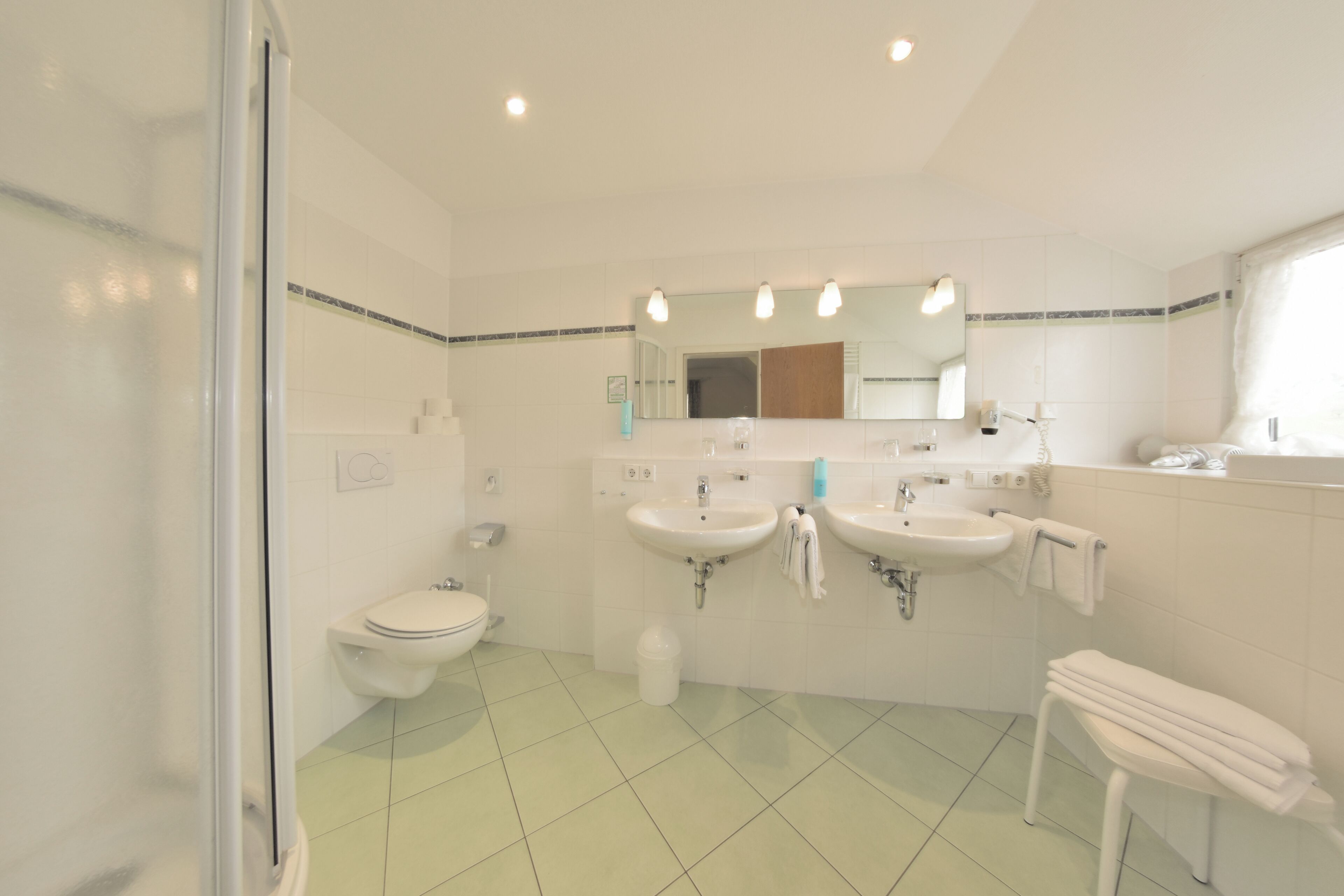 Un baño con dos lavabos, un inodoro y una ducha.