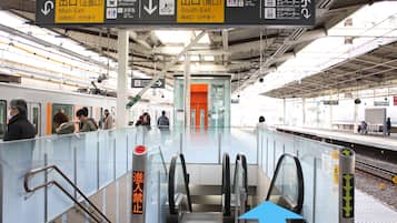 A train station platform with directional signs for exits, toilets, and elevators.