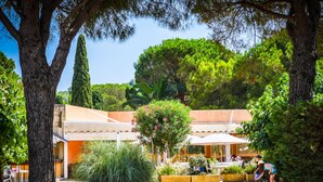 A courtyard with outdoor seating, surrounded by trees and plants. - Vacances Passion La Grande Bastide (Le Lavandou)