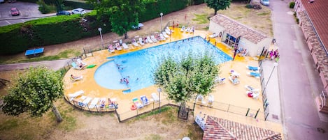 Een seizoensgebonden buitenzwembad, parasols voor strand/zwembad