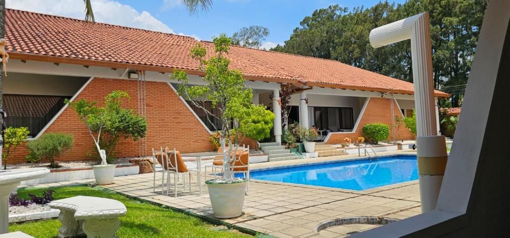 Une maison avec une piscine, un espace extérieur aménagé et un jardin.