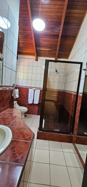 Een aparte badkuip en douche, een diep bad, een hydromassagedouche