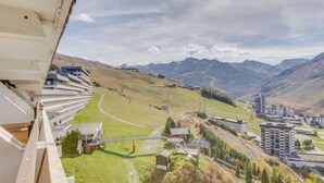 A hotel with a view of a mountainous landscape, including a winding road and several buildings.