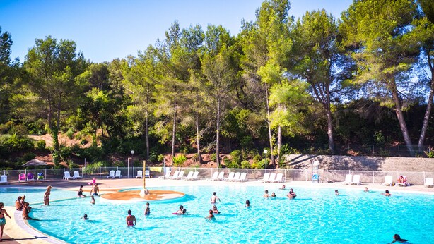 A swimming pool with multiple lanes, surrounded by trees and a fenced area with lounge chairs. - Vacances passion - Village La Bayette (Le Pradet)