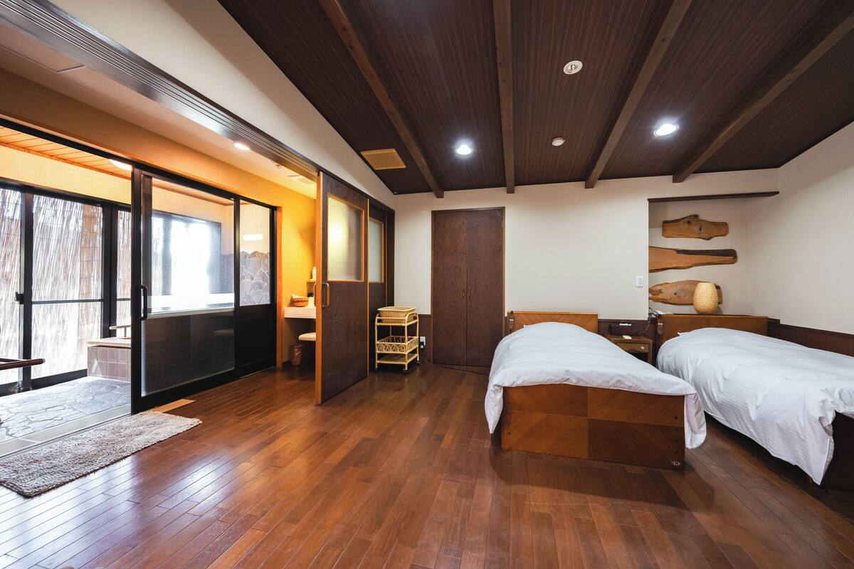 Une chambre moderne avec un plancher en bois, un lit, un bureau et une grande fenêtre.