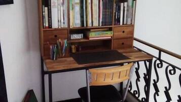 A study area with a wooden desk, bookshelves, and a ladder.