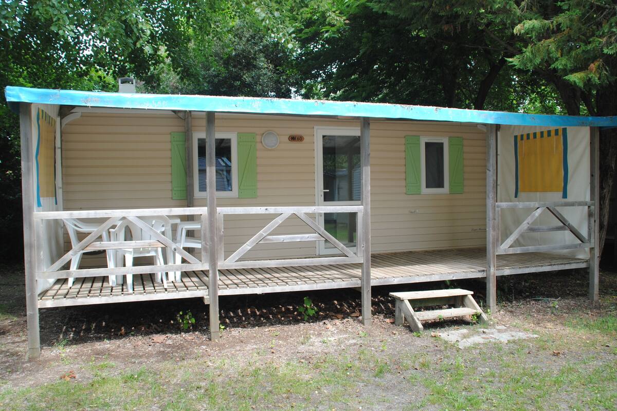 Une petite cabane en bois d’un seul étage, dotée d’un porche et d’un espace abrité.