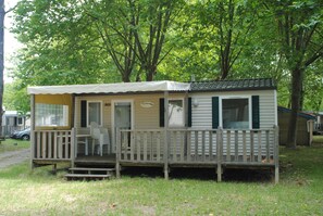 A small, single-story mobile home with a porch and a small deck. - Vacances Passion Les Bris (Saint-Trojan-les-Bains)