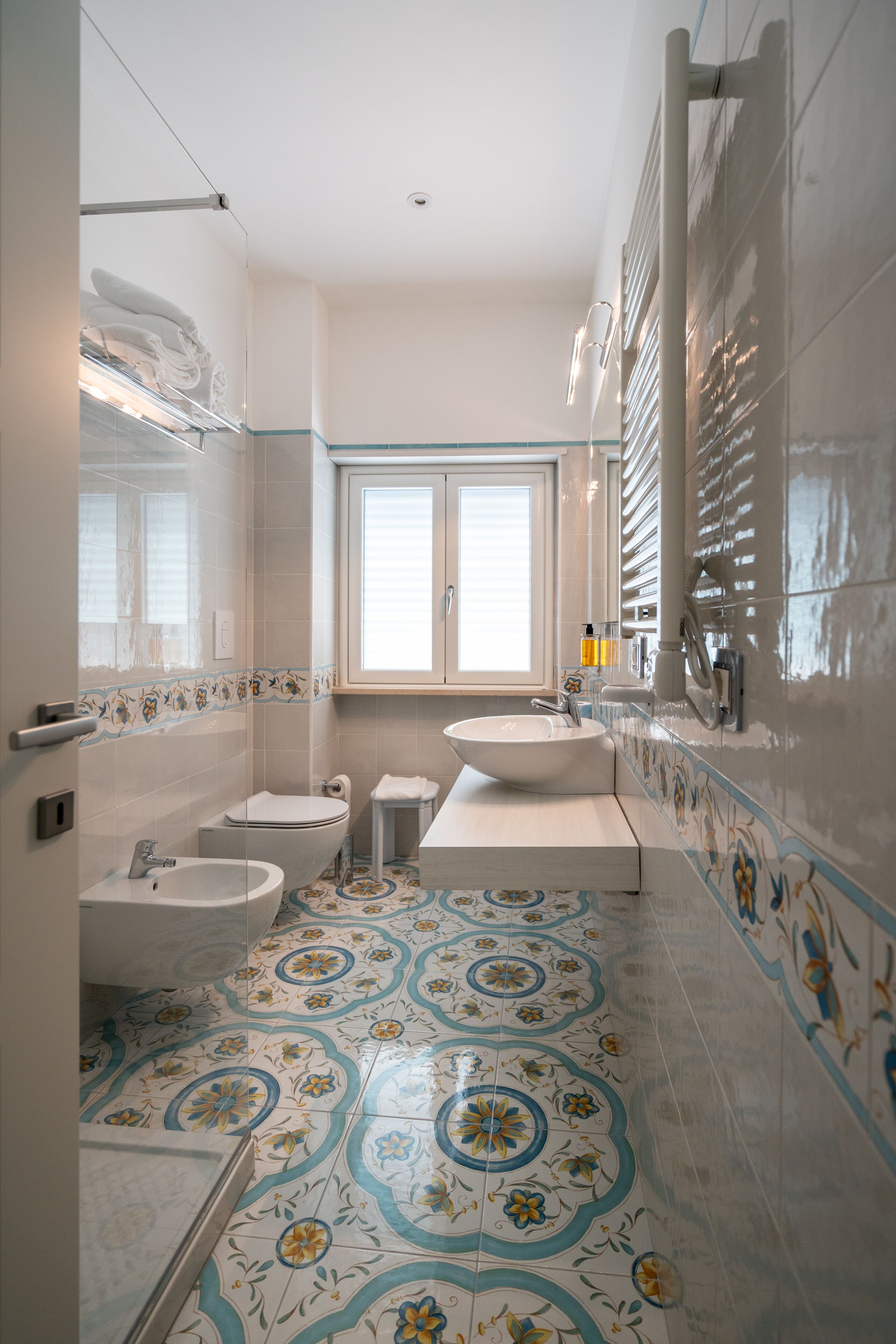 Un baño con una ventana grande, un lavabo, un inodoro y una bañera.