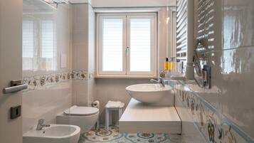 Un baño con una ventana grande, un lavabo, un inodoro y una bañera.