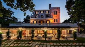 Een gebouw met twee verdiepingen, een restaurant op de begane grond en de naam "Villa Maria" op de tweede verdieping.