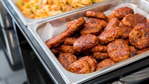 A buffet with various dishes including meatballs, pasta, and fries.