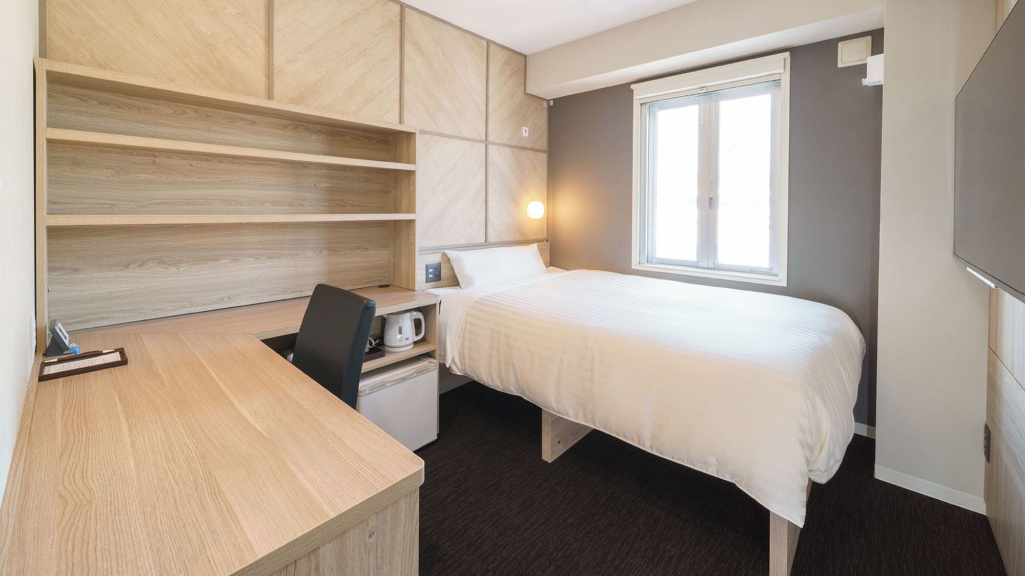 Une chambre à coucher avec un lit, un bureau, une chaise et une fenêtre.