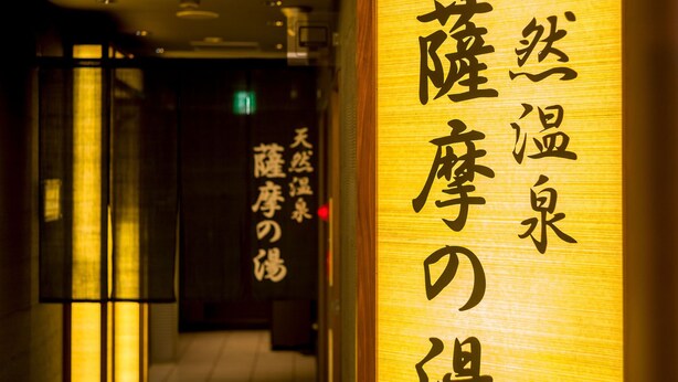 A corridor with traditional Japanese signage and illuminated panels.