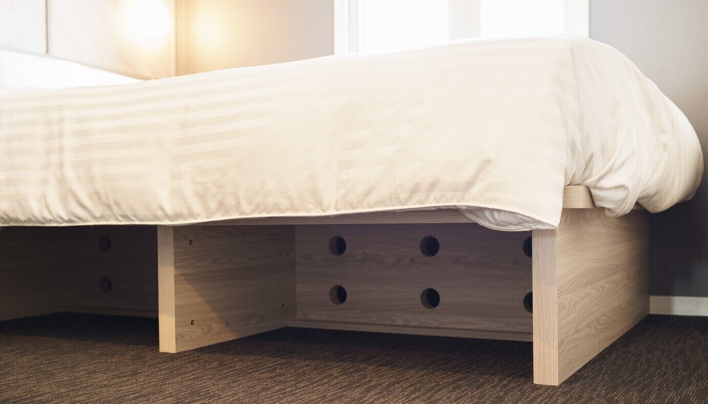 Un lit avec un cadre en bois et des tiroirs de rangement situés en dessous.