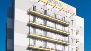 A multi-story hotel with a yellow sign indicating a price of 4,980 yen per night.