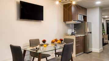 A modern kitchen with a built-in microwave, stainless steel refrigerator, and wooden cabinets.