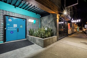 Un edificio con puerta azul identificada con 'easy living' y un letrero que indica servicio de 'Valet'.
