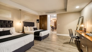 Quarto de hotel com duas camas, uma escrivaninha e uma cadeira.