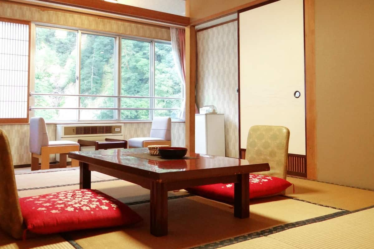 Une pièce de style japonais traditionnel, avec un sol recouvert de tatamis, une table basse et une porte coulissante.