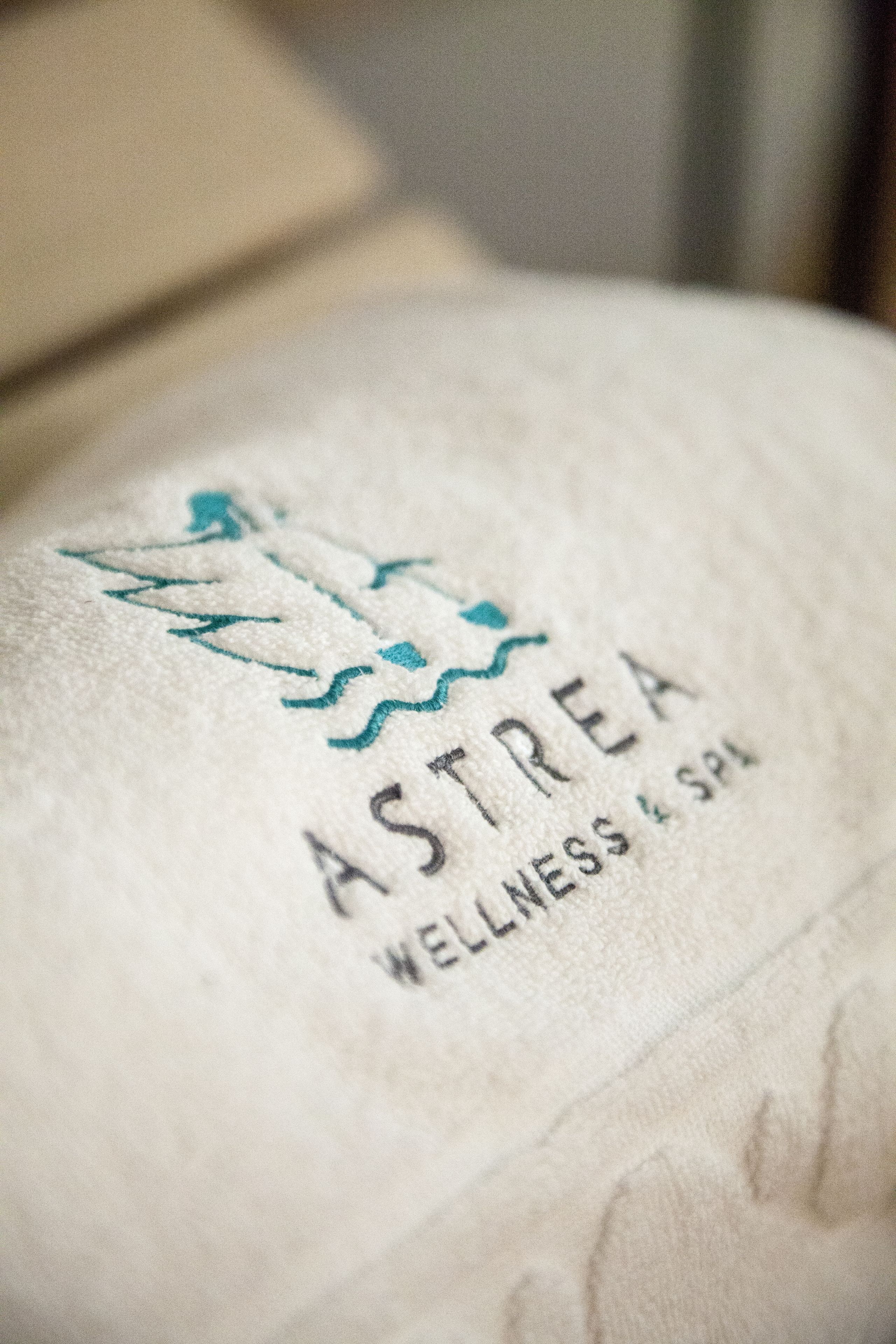 A towel with the logo and name "ASTREA WELLNESS & SPA".