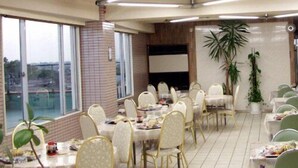 A spacious dining area with high ceilings, large windows, and modern lighting fixtures.