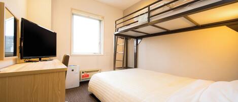 A hotel room with a bunk bed, a desk with a flat-screen TV, a window, and a radiator.