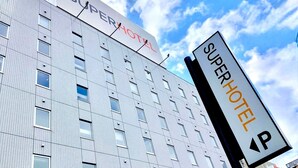 A modern building with a sign reading "SuperHotel" and a parking sign indicating a parking area. - Super Hotel Kitami (Kitami)