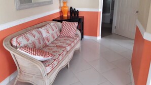 A living room with a sofa, a small table, and a vase of dried flowers. - Balata Splendour Apartment (Gros Islet)