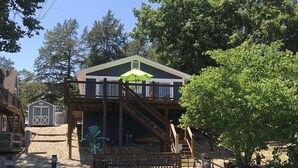 Une terrasse en bois avec un escalier menant à un bâtiment doté d’un toit végétalisé.