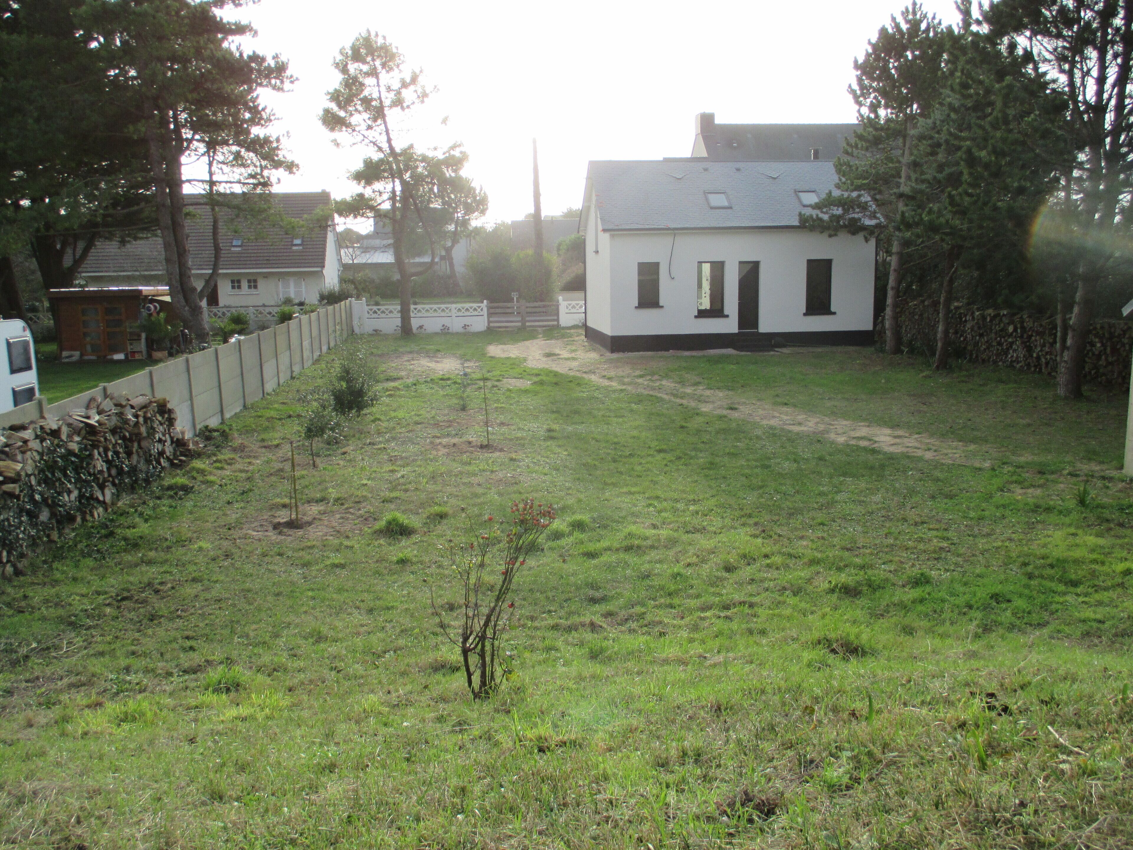 Il s’agit d’une propriété résidentielle dotée d’une cour clôturée, d’une petite maison avec un toit en pente et d’un garage bien visible.
