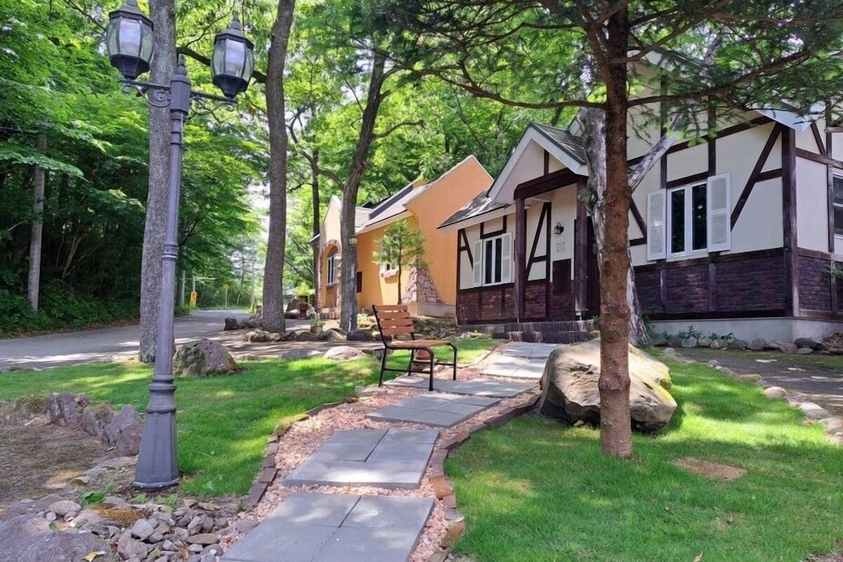 A residential property with a stone pathway, a bench, and two houses with distinct architectural styles.