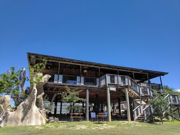 A wooden building with a balcony and outdoor seating area.