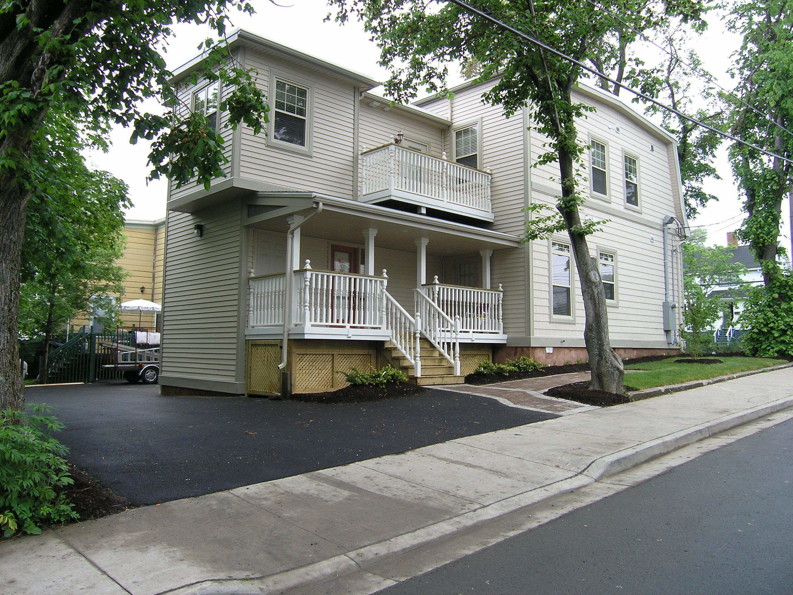 A two-story house with a front porch and a small balcony.
