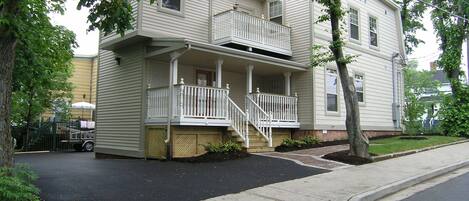 A two-story house with a front porch and a small balcony.