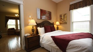 A bedroom with a bed, two bedside lamps, a nightstand, a chair, and artwork on the walls. - Windmill walk (Dartmouth)