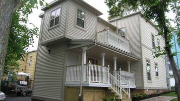 A two-story house with a front porch and a small balcony.