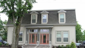A two-story house with a front porch, a garage, and a driveway.