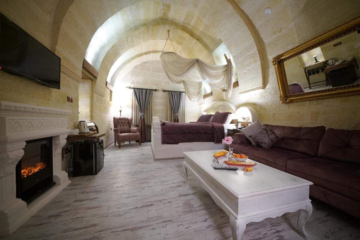A spacious living room with a fireplace, a television, a sofa, and a coffee table.