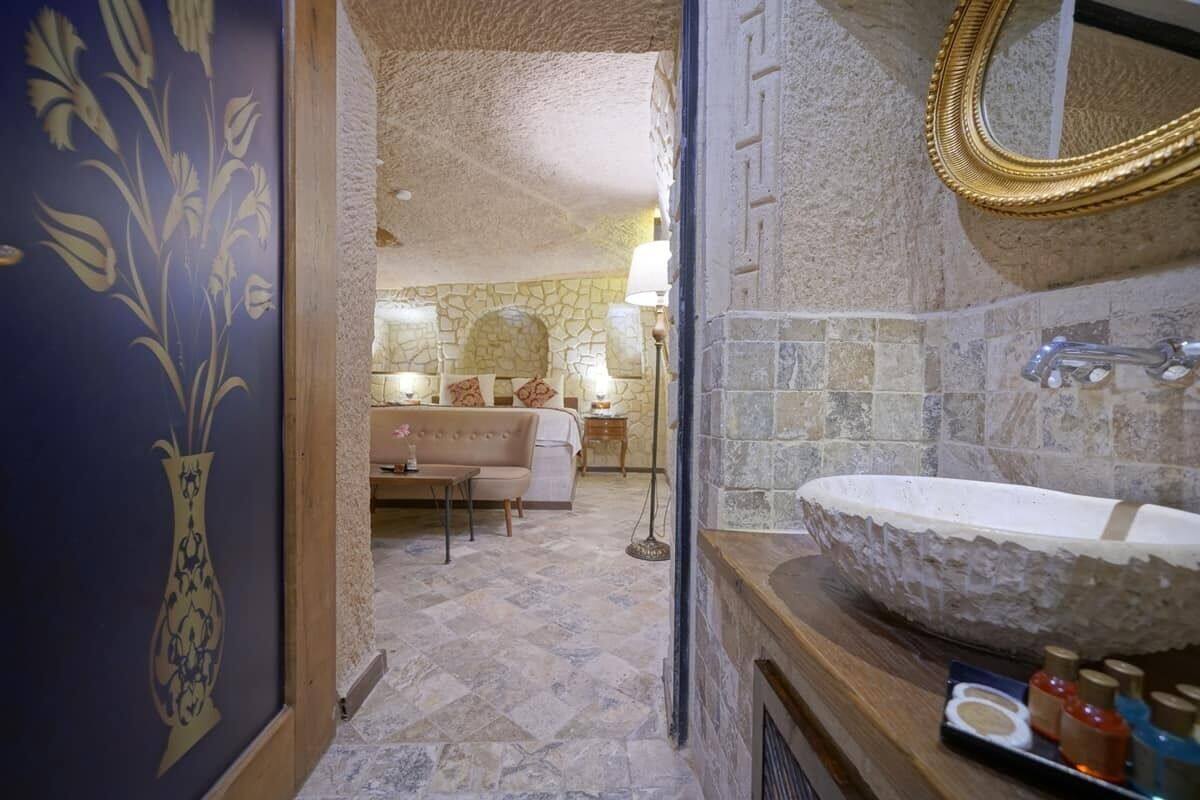 A bathroom with a stone sink, a mirror, and a towel rack.
