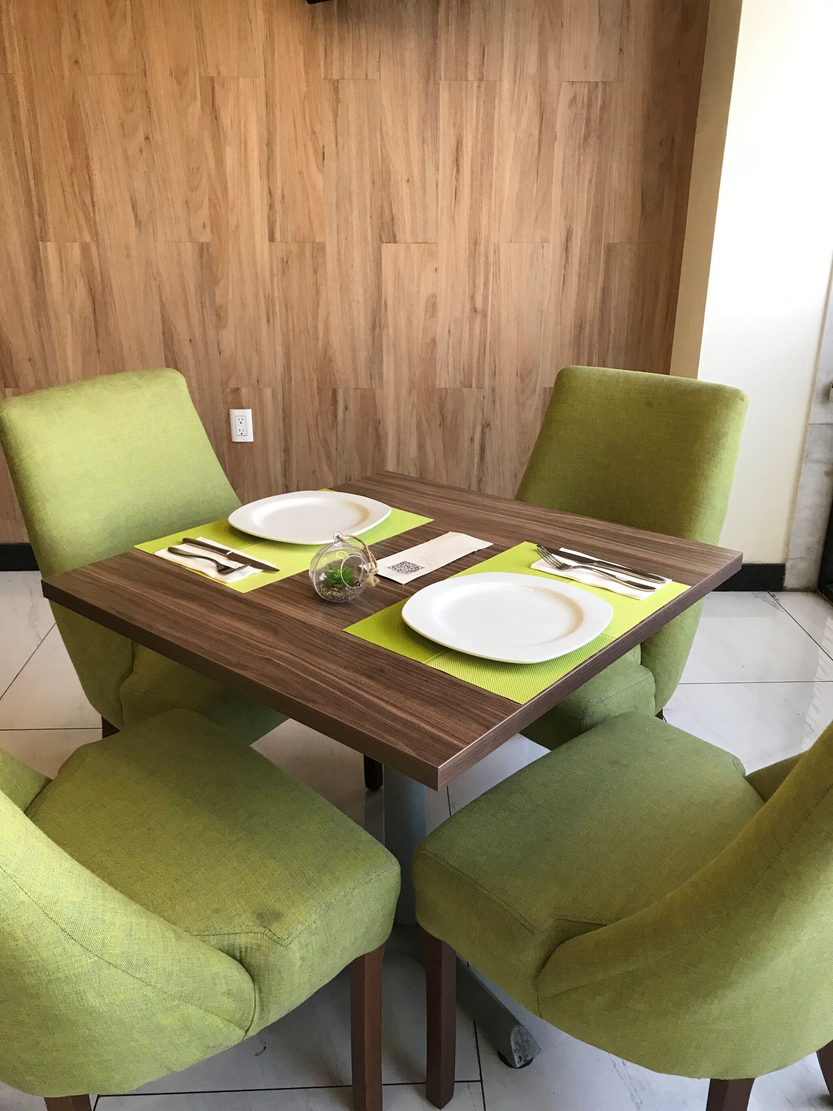 A dining table with two chairs, a QR code, and a small decorative item.