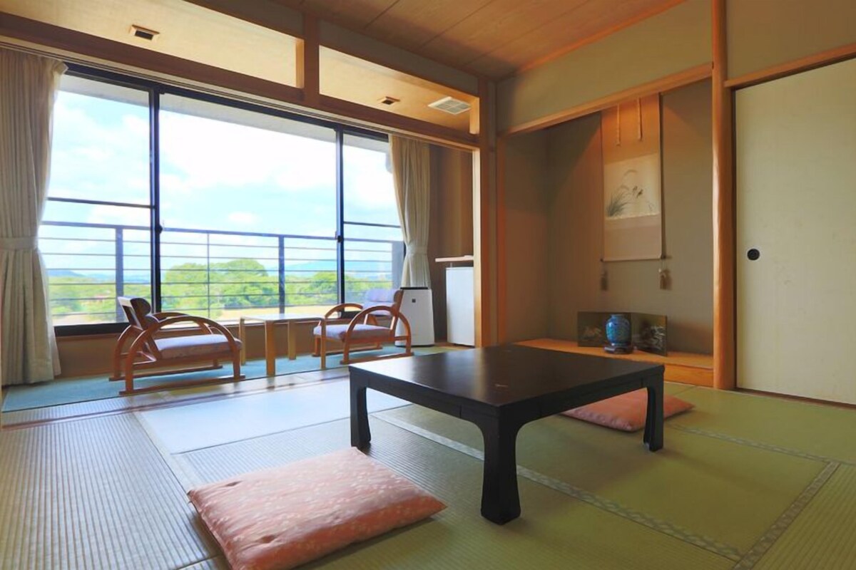 Een traditionele Japanse kamer met tatami vloerbedekking, een lage tafel en schuifdeuren.